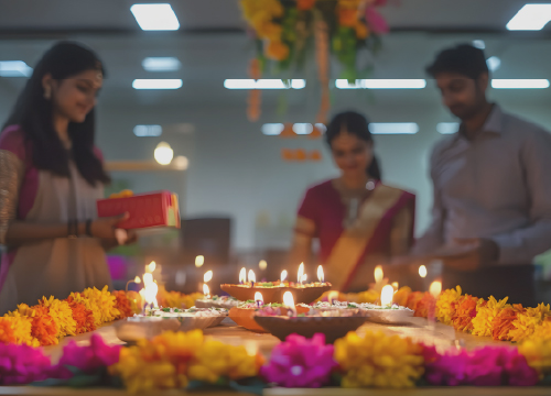 Three employees around candles and flowers for employee engagement in India.