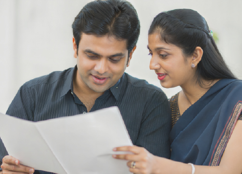 Man and woman looking at a life insurance form as part of the benefits offiered.